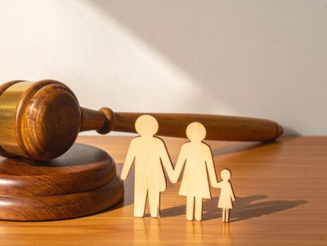 Wooden Judge Gavel and Sound Block Next to a Wooden Family Cutout on a Desk