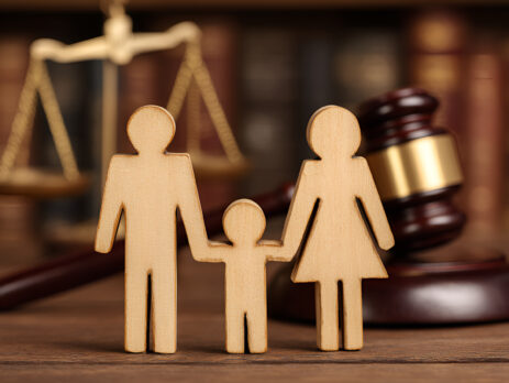 Wooden family figures are holding hands