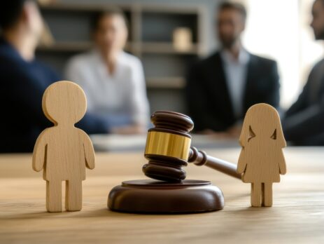 A family wooden figure and gavel on a judge's table